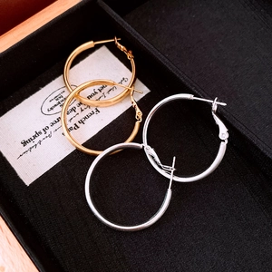 Dettaglio di orecchini a cerchio in oro e argento con finitura spazzolata