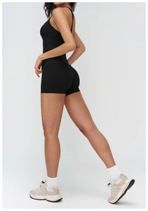 Close-up of seamless black yoga set featuring high-waist shorts and racerback sports bra