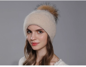 Elegant beige Angora rabbit fur knit beanie featuring a large raccoon fur pom pom