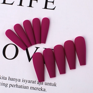 Macro shot of 10 matte burgundy press-on nails in long coffin shape on white background