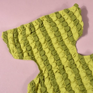 Detailopname van geel-groene popcornstof met gestreepte textuur en hoge elasticiteit
