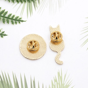 Detail view of gold metal badges back showing butterfly clutches and mesh texture details