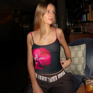 Close-up of pink floral print on a black slim-fit crop tank top with thin straps