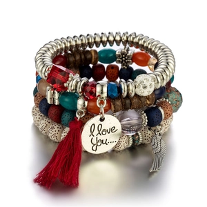 Bohemian multilayered beaded bracelet with colorful tassels, wing charms and wood beads