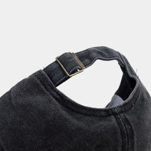 Detail of adjustable brass buckle and washed cotton texture on vintage baseball cap