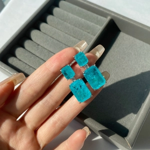 Detailed close-up of 925 silver earrings with rectangle cut Paraiba blue gemstones