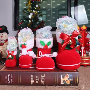 Set of four red flocked Christmas candy boots in various sizes on a vintage book