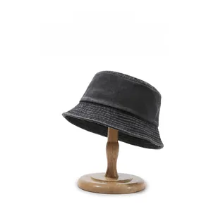 Detail view of charcoal washed cotton bucket hat showing breathable vents on wooden stand