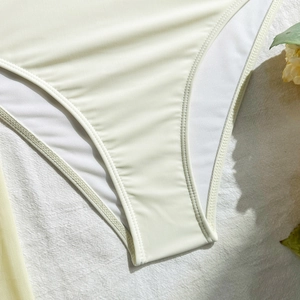 Detail van het dubbelnaalds platte stiksel op de elastische crème bikini-stof