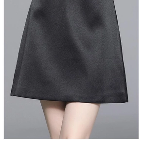 Detailed view of black satin dress hem showing elegant heavy beadwork and lace splicing