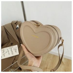 Dettaglio della borsa a cuore beige in pelle PU con zip dorate e tracolla regolabile