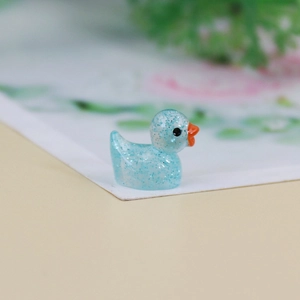 Macro shot of a light blue glowing resin duck miniature with glitter for DIY decor