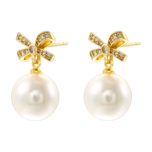 Elegant gold bow earrings with pearls and zircon stones on a white background