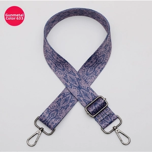 Detail of adjustable gunmetal hardware on a blue snakeskin pattern bag strap