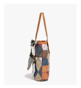 Detail of color-block tote bag featuring side stitching and printed silk scarf accessory
