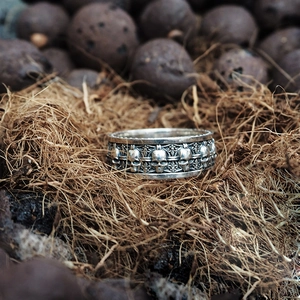 Macro shot of vintage S925 silver skull ring with ornate iris patterns and aged finish