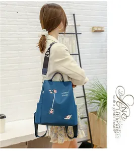 Detail der blauen 3D-Blumenstickerei und stylischen Schultergurte am wasserfesten Rucksack