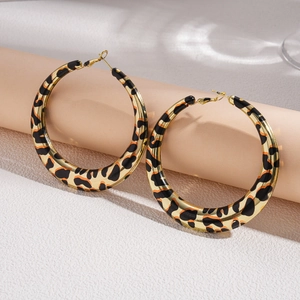 Exaggerated leopard print hoop earrings in gold metal for a bold vintage fashion statement