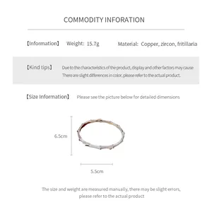Detail of gold plated bangle featuring hollow geometric lace and zircon butterfly stones