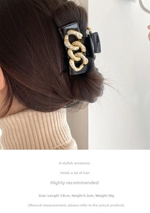 Detail of square black hair claw clip with gold chain accent, 7.8cm long for hair styling
