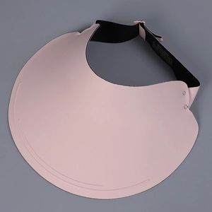 Detailed view of pink sun visor brim with black adjustable strap and fabric label