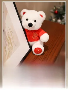 Close-up of white polar bear plush in red embroidered Tang suit with gold cloud patterns