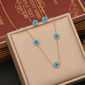Macro view of gold stainless steel devil eye necklace and matching stud earring set