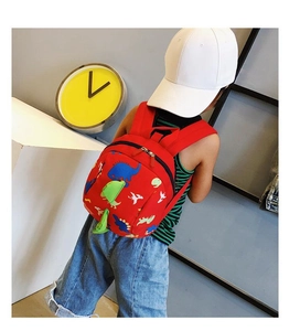 Detailed back view of a red toddler backpack featuring colorful cartoon dinosaur prints