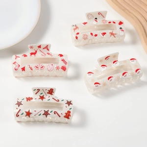 Festive Christmas acetate hair claw clips with Santa and snowman patterns on white tray