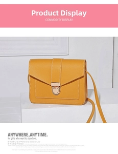 Detail of yellow crossbody bag with cross-grain leather texture and golden metal clasp