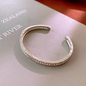 Detailed view of silver C-shaped cuff bracelet with cubic zirconia and polished finish