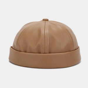 Detailed view of the brown PU leather skull cap with fine stitching and top button