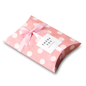 Detailed view of a pink polka dot pillow gift box with a pink ribbon and thank you sticker