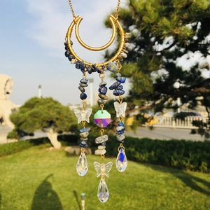 Detail of moon-shaped suncatcher with natural blue crystals and butterfly pendants