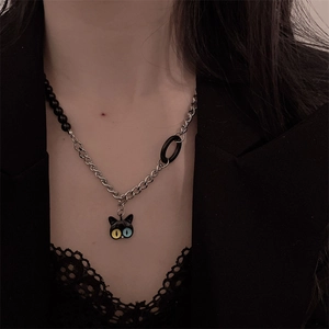Detail of a dark gothic cat necklace with heterochromia eyes on a model in a black suit