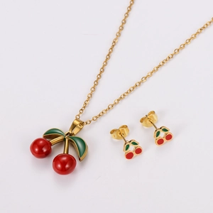 Detailed view of cherry-shaped enamel necklace and stud earrings set in gold finish