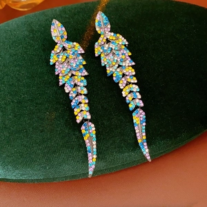 Vue macro détaillée de boucles d'oreilles plumes vintage serties de strass colorés