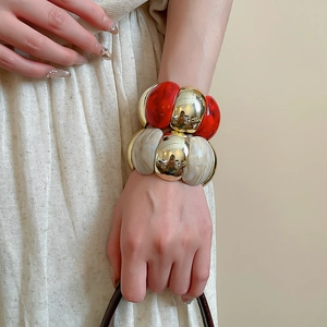Close-up of marble acrylic and gold metal stretch bracelet on woman's wrist