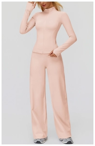 Detail of light pink yoga set featuring slim-fit zip top with thumb holes and wide-leg pants