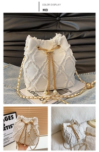 Detail of cream white bucket bag featuring quilted fabric, tassel edges, and pearl gold chain