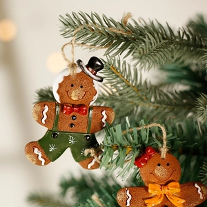 Gingerbread man Christmas tree hanging ornaments with warm holiday background lighting
