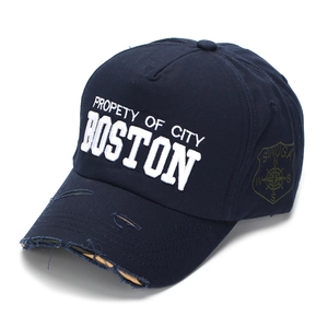 Detail of distressed navy blue baseball cap with 3D embroidery and worn brim edge