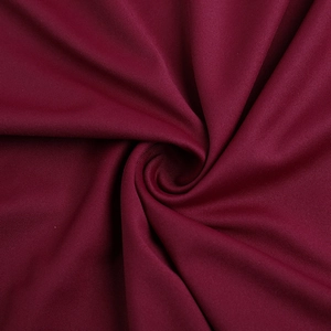 Detailed macro view of burgundy lace fabric showing fine texture and soft draping quality