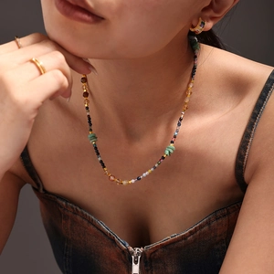Gros plan d'un collier de perles en pierres naturelles et pendentifs opale sur un mannequin