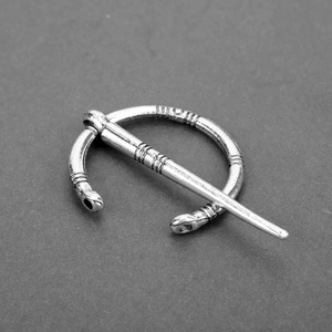 Macro detail of silver vintage Viking brooch pin featuring Celtic animal head design