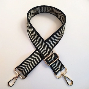 Close-up of wide adjustable nylon shoulder strap with gold chevron jacquard pattern