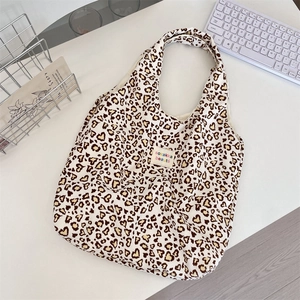 Detail view of heart-shaped leopard print canvas tote bag with woven sozakka label