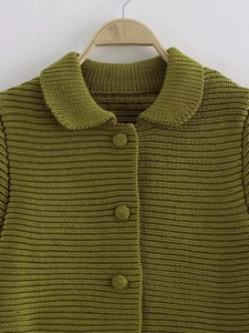 Close-up of grass green chunky knit cardigan with textured wave stitch and matching buttons