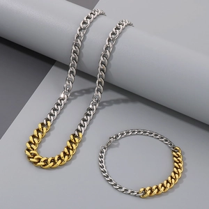 Detailed close-up of two-tone gold and silver Cuban link necklace and bracelet set