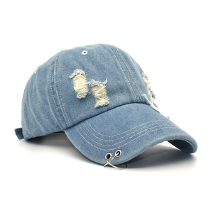 Detail of distressed denim baseball cap featuring metal rings and vintage torn effects